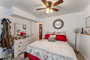 Carpeted bedroom with ceiling fan