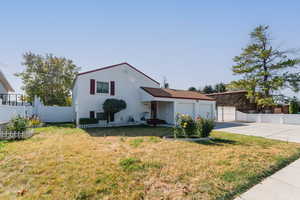 View of front of home with a front lawn and a garage