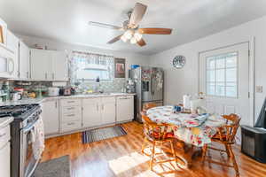 Kitchen with appliances with stainless steel finishes, plenty of natural light, decorative backsplash, and white cabinets