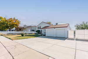 View of front of property with a garage and a front lawn