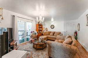 Living room with light hardwood / wood-style floors and an inviting chandelier