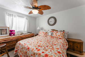 Carpeted bedroom with ceiling fan