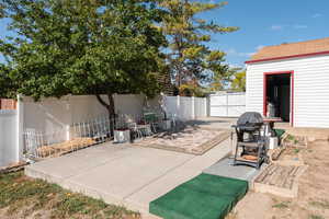 View of patio featuring area for grilling and an outdoor structure