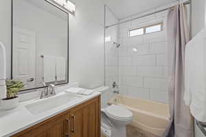 Full bathroom featuring vanity, toilet, and shower / tub combo with curtain