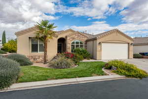 Mediterranean / spanish house with a front yard and a garage