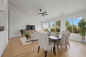 Dining room featuring light hardwood / wood-style flooring, lofted ceiling, plenty of natural light, and ceiling fan