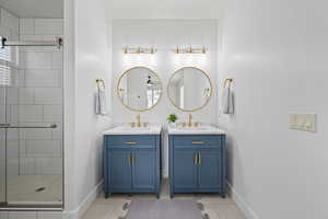 Bathroom with vanity, tile patterned floors, and a shower with shower door