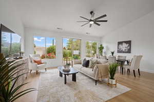 Living room featuring lofted ceiling, light hardwood / wood-style floors, and ceiling fan