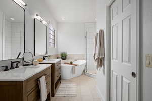 Bathroom with tile walls, vanity, separate shower and tub, and tile patterned floors