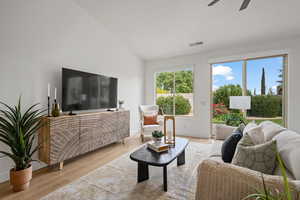 Living room featuring high vaulted ceiling, light hardwood / wood-style floors, and ceiling fan