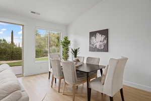 Dining space with lofted ceiling and light wood-type flooring