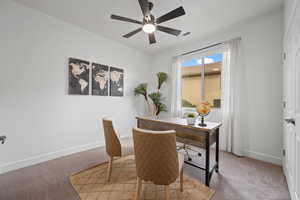 Carpeted office space featuring ceiling fan