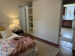 Bedroom with wood-style floors and connected bathroom