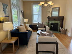 Living room with light hardwood flooring, a fireplace, radiator, and plenty of natural light