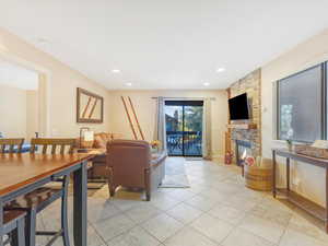 Tiled living room featuring a stone fireplace