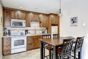 Kitchen featuring sink, decorative light fixtures, white appliances, light stone countertops, and decorative backsplash