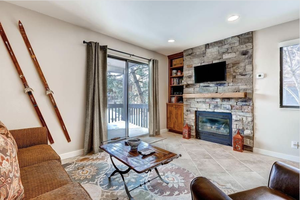 Tiled living room with a fireplace and built in shelves