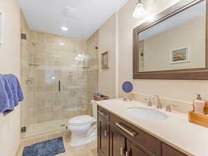 Bathroom with vanity, tile patterned flooring, toilet, and an enclosed shower