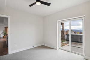 Carpeted spare room featuring ceiling fan