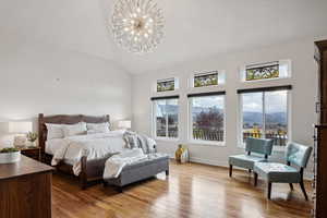 Bedroom with vaulted ceiling, light hardwood / wood-style flooring, a mountain view, and an inviting chandelier