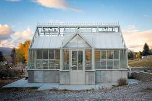 Back house at dusk featuring a sunroom