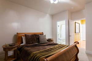 Bedroom featuring light carpet and ensuite bath