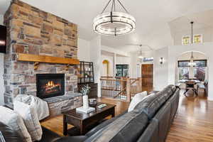 Living room with a fireplace, hardwood / wood-style flooring, and high vaulted ceiling