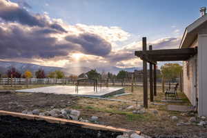 Yard at dusk with a rural view and a mountain view