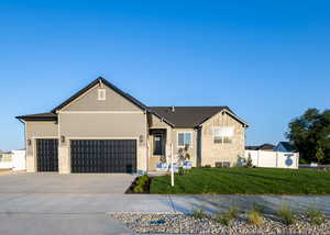 View of front of house featuring a front yard and a garage