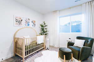 Bedroom with a nursery area and carpet flooring