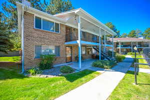 View of front of home with a balcony and a front lawn