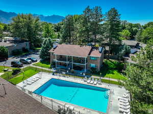 View of pool with a patio, a mountain view, and a lawn