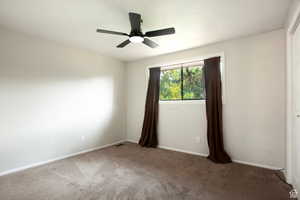 Carpeted spare room featuring ceiling fan