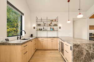 Kitchen featuring light hardwood / wood-style flooring, light brown cabinets, sink, and kitchen peninsula