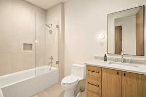 Full bathroom featuring vanity, toilet, tile patterned flooring, and tiled shower / bath