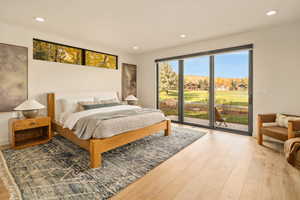 Bedroom with access to outside and hardwood / wood-style floors