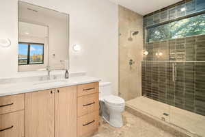 Bathroom with vanity, toilet, plenty of natural light, and an enclosed shower