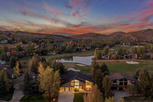 Aerial view at dusk featuring a water and mountain view