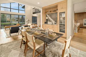 Dining space featuring sink, a high ceiling, and light hardwood / wood-style floors