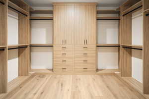 Spacious closet featuring light hardwood / wood-style floors