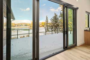 Doorway to outside featuring a water view and light wood-type flooring