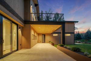 Exterior entry at dusk with a yard and a balcony