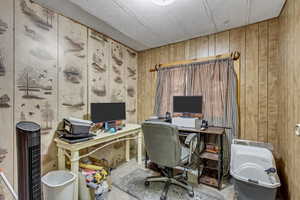 Tiled home office featuring wooden walls