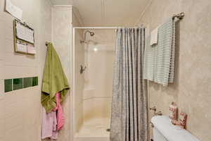 Master bathroom with a shower with shower curtain and toilet