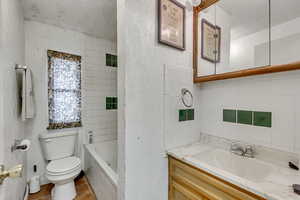 Bathroom with vanity, a textured ceiling, toilet, and tile patterned floors