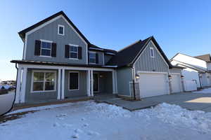 View of front of home featuring a garage and a porch