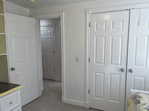 Unfurnished bedroom with light carpet and a closet