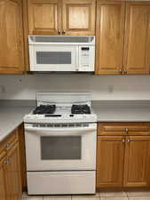 Kitchen with white appliances and light tile patterned floors