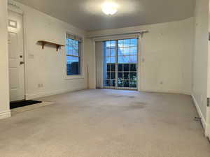 Carpeted empty room featuring a textured ceiling