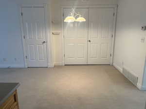 Unfurnished dining area featuring light carpet and an inviting chandelier